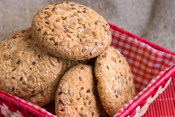 Savory cookies sprinkled with sesame seeds, sunflower on table and burlap background
