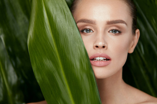 Beauty Woman Face With Healthy Skin And Green Plant