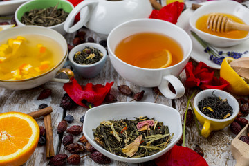 Various leaves of tea and spices on wooden background