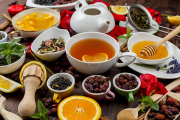 Various leaves of tea and spices on wooden background