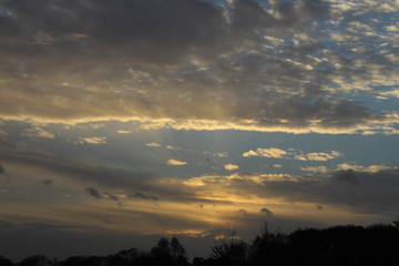 Obraz premium Blue sky with an assortment of clouds and an amazing sunset with treest and foliage in the foreground