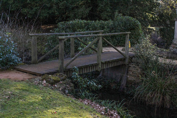 Fototapeta premium Wooden footpath bridge crossing a stream