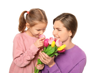 Fototapeta na wymiar Portrait of mother and cute little daughter with flowers on white background