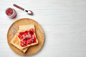 Toasts with jam on wooden background, top view