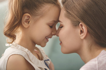 Portrait of happy mother and daughter at home, closeup