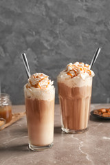 Glasses with delicious caramel frappe on table