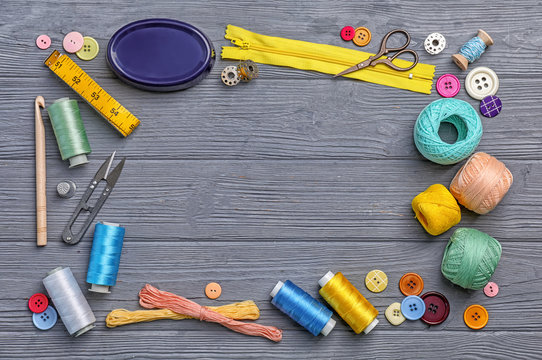 Flat lay composition with sewing threads and accessories on wooden background