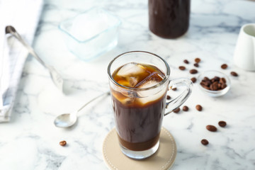 Glass cup with cold brew coffee on light background
