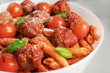 Delicious pasta with meatballs and tomato sauce on plate, closeup