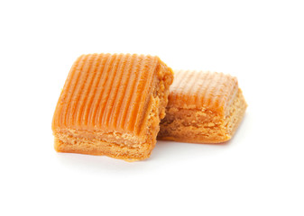 Delicious caramel candies on white background