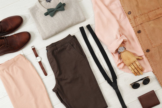 Flat lay set of stylish clothes and accessories on wooden floor