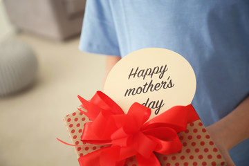 Little child with gift box for Mother's Day at home