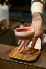 Professional bartender making a cocktail at the bar counter, close-up