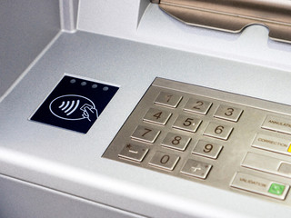 New modern ATM bank teller automatic bank machine with contactless sign next to the keyboard keypad...