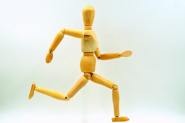 Wooden mannequin figure running.