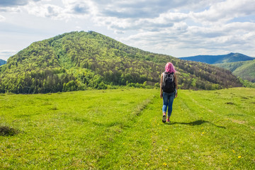 Backpack girl with pink hair on beautiful nature forest mountain landscape