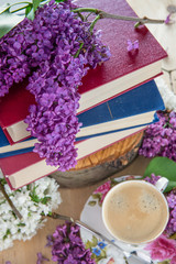 Spring mood, background. Books ,coffee, and branches of lilac
