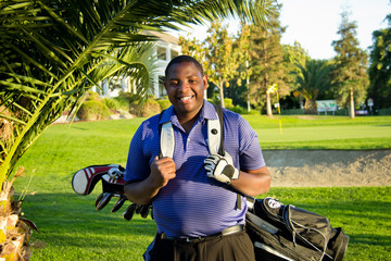 African American young man with golf clubs posed