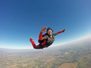 Rolgordijnen Smiling black woman jumping from parachute © Mauricio G
