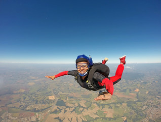 Smiling black woman jumping from parachute