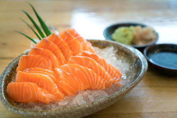 Raw salmon slice or salmon sashimi in Japanese style fresh serve on ice in bowl.