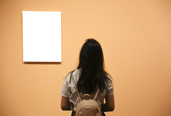 Woman in a gallery looking at empty frames