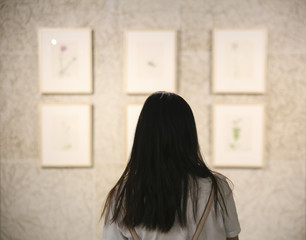 Woman in a gallery looking at empty frames