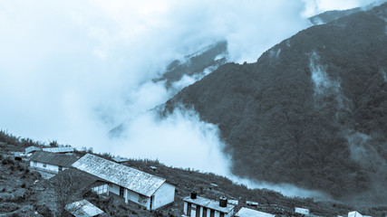 A hilltop View of beautiful misty mountain range with zuluk village.