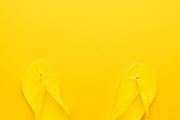 beach flip-flops on the yellow background with copy space. summer concept