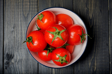 Tomatoes on dark rustic background.