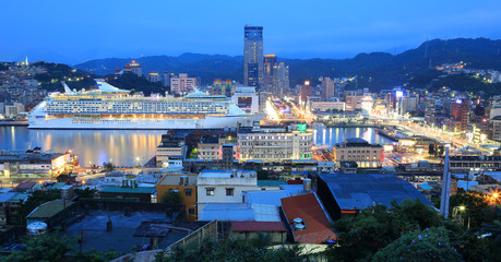 Panorama of Keelung City at dusk, a busy seaport in northern Taiwan, with view of a cruise liner...