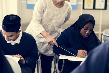 diverse muslim children studying in classroom
