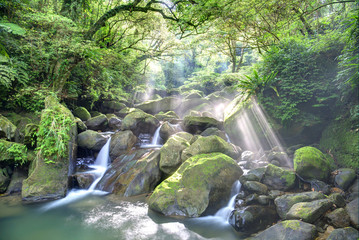 Beautiful waterfalls and sunbeams in jungle ~ Refreshing cascades in a mysterious forest with rays of sunlight shining through the misty air in lush greenery ~ River scenery of Taiwan