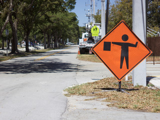 Flagman sign with blurred heavy equipment in distance