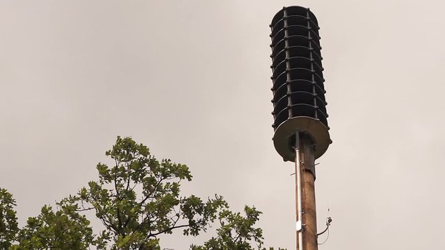 Very low angle of a tornado siren on a cloudy day