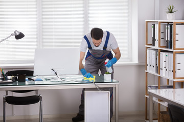 Male Worker Cleaning Office Desk