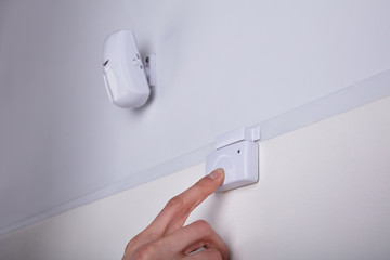 Person Pressing Security System Door Sensor