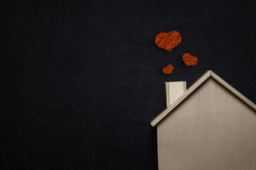 Home sweet home with red heart. Wooden house and Black leather background. Happy family lifestyles...
