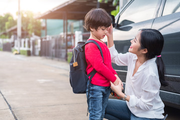 Mom preparing to send her children back to school at car in morning. Education and Back to school...