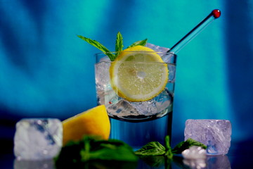 Vodka soda with ice cubes and fresh mint leaves.