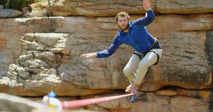 Mountaineer trying to get balance on the rope 