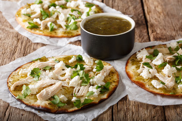 Delicious hot chalupas with chicken, cheese and green sauce close-up on the table. horizontal