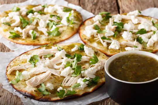 Delicious mexican chalupas with queso fresco and chicken meat and green sauce close-up. horizontal