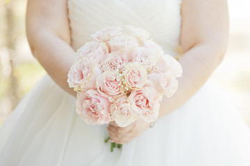 Obraz na płótnie Canvas Bride holding a natural pink rose bouquet 