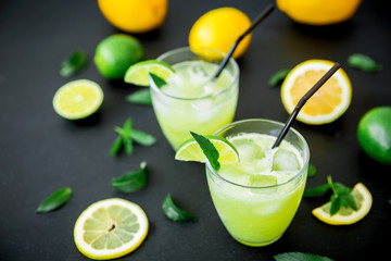 Glass of refreshing lemonade with limes and lemons 
