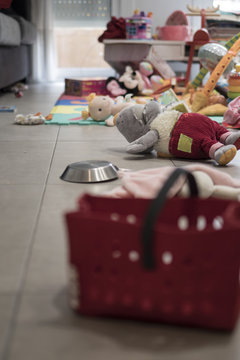 Many toys untidy on a grey floor indoor