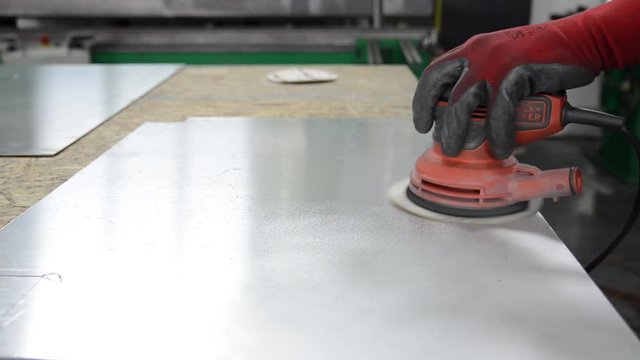 Worker with random orbital sander. Grinding and polishing metal. Man working hard in factory. Mechanic worker. Car industry. 