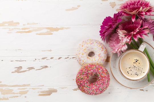 Coffee cup, donuts and gerbera flowers
