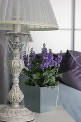 Bedside table, lamp, pot with flower, interior in Provence style