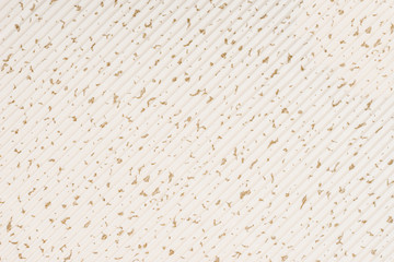 Striped embossed beige paper. Colored paper with gold dots texture background